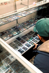Person looking at sports cards in a display case to buy sell trade