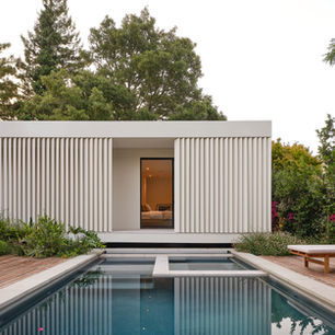 Modern poolside house with vertical slat design.