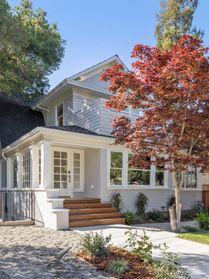 Charming house with trees and a cobblestone path.