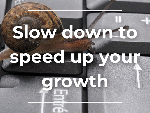Image of a snail crawling on top of a keyboard with the words 'slow down to speed up your growth'.