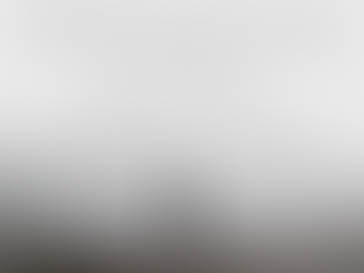 Photo of a person standing on the edge of a cliff looking out into an abyss of fog
