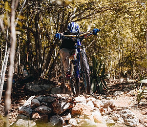 guy riding bicyle in the woods
