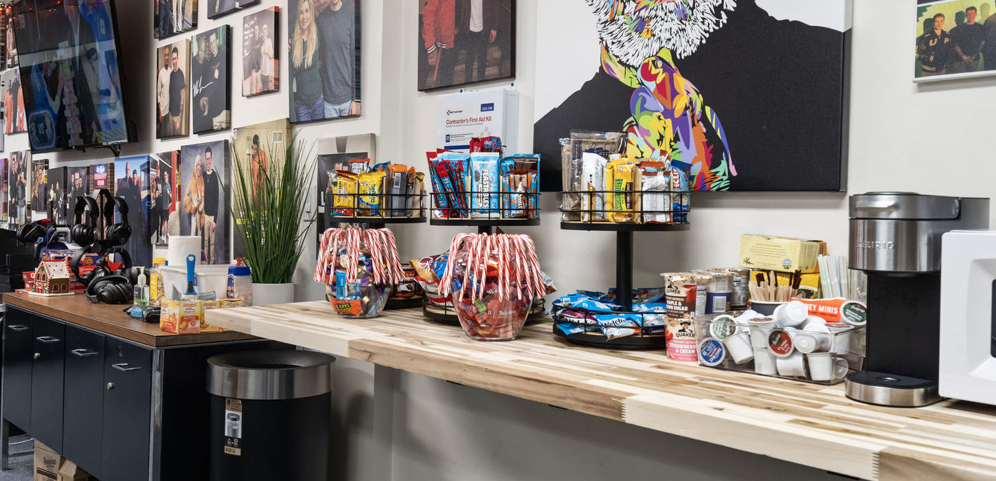 Long snack bar wall at the Locked In With Ian Bick studio with candy displays, beverage station, and guest photo wall.