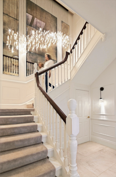 Grand staircase design with bespoke contemporary chandelier and antique mirror with wall paneling