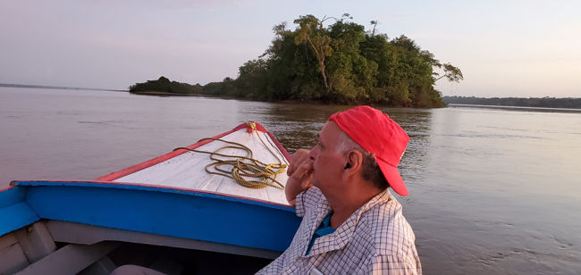 Sloth island staff look for parrots as they come to parrot island in the background.