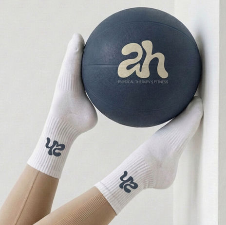 AH Physical Therapy logo mockup on sock and medicine ball