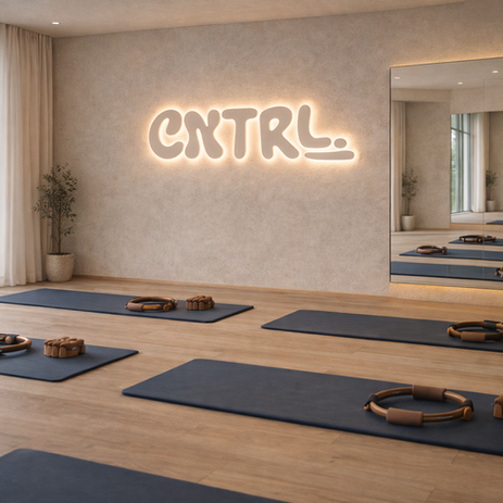 CNTRL pilates studio mockup with CNTRL logo lit up on back wall and yoga mats on the floor