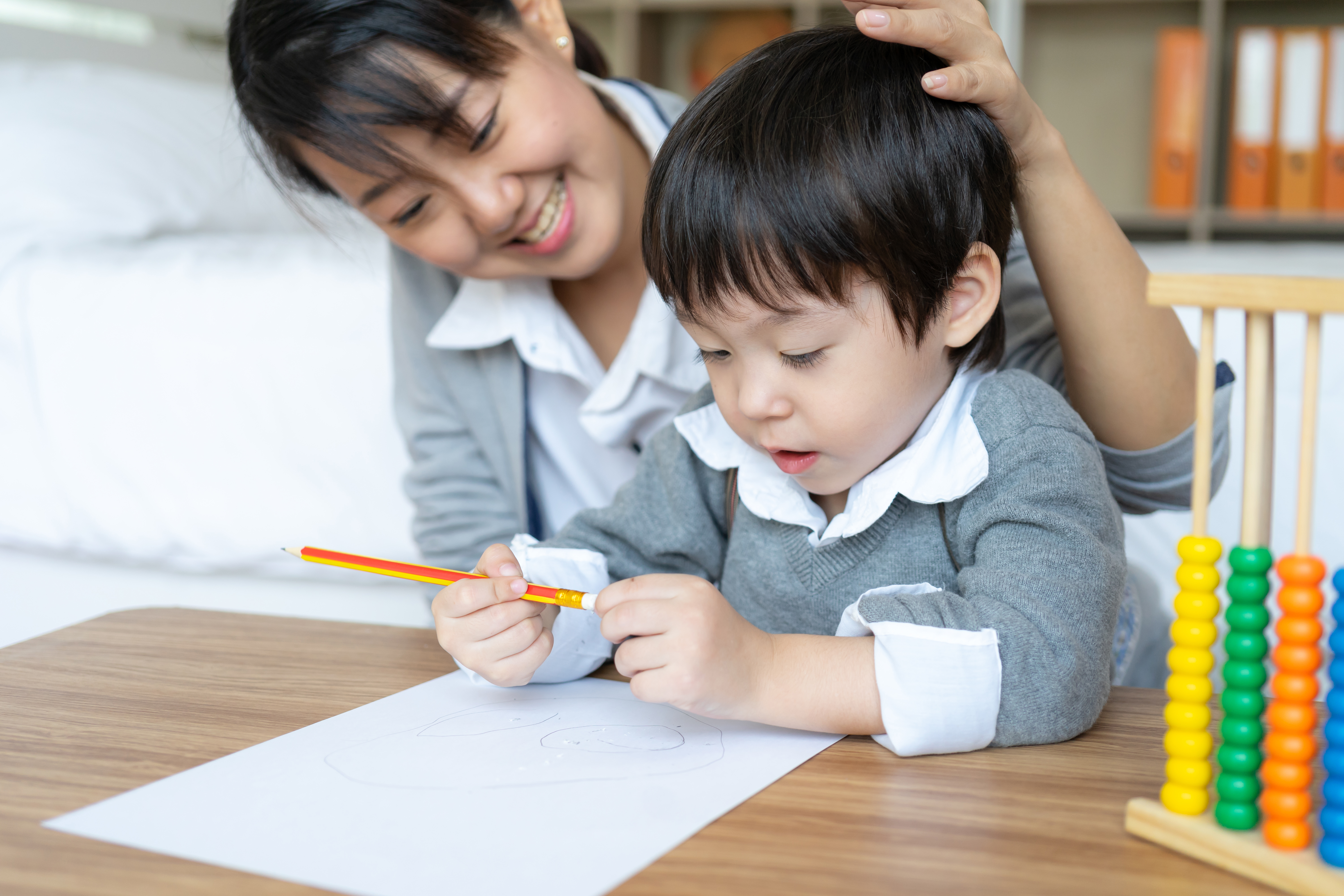 young-mother-teaching-her-son-write-paper-with-love.jpg