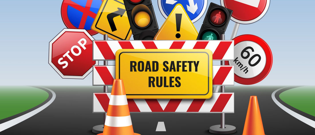 Illustration of road signs, traffic lights and cones under a "Road safety rules" sign