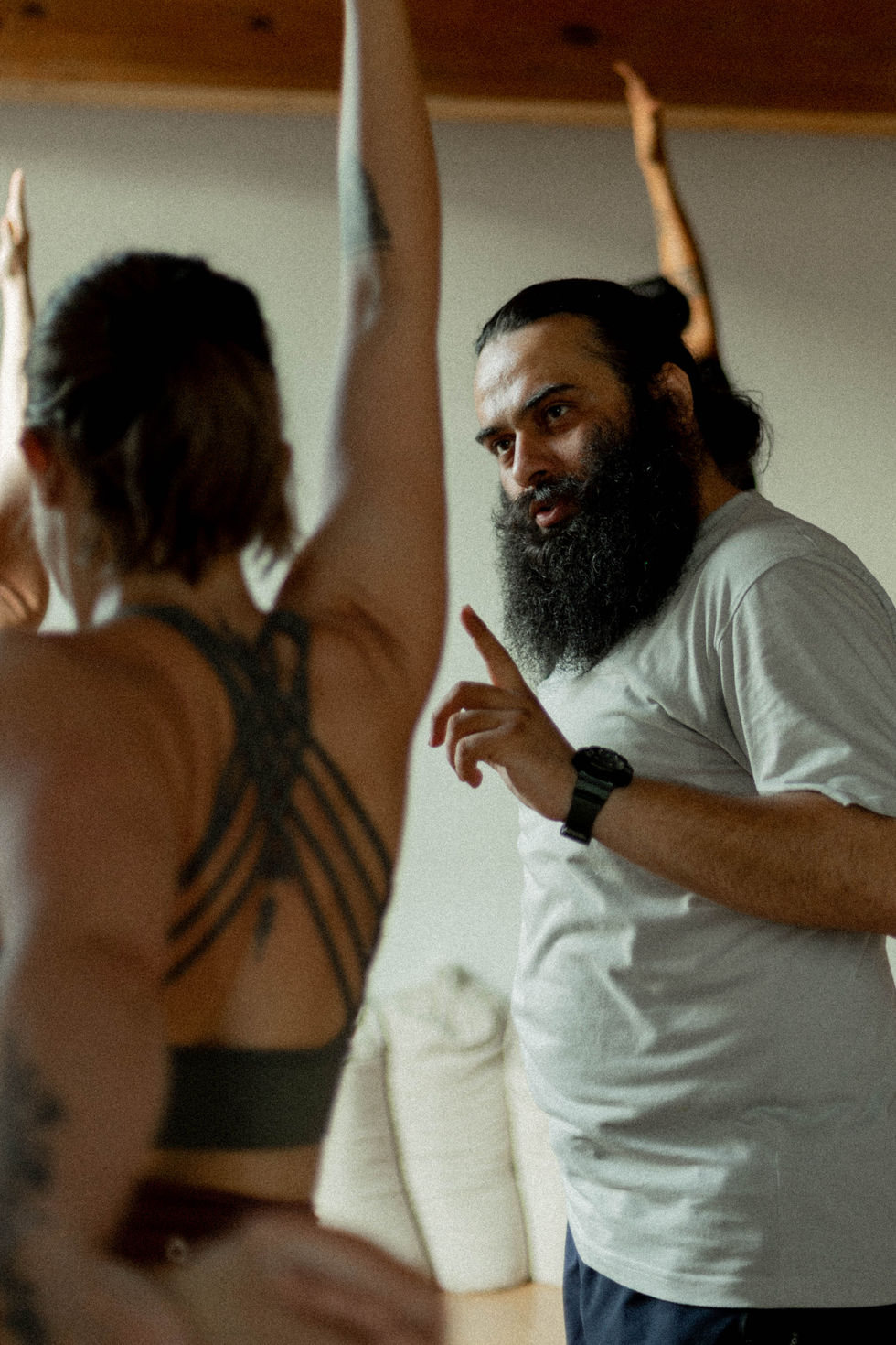 Instructor de yoga guiando a una alumna en una postura