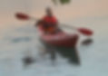 man paddling kayak with one hand