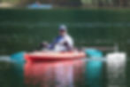man in an adapted kayak with angled paddle and hand adaptations