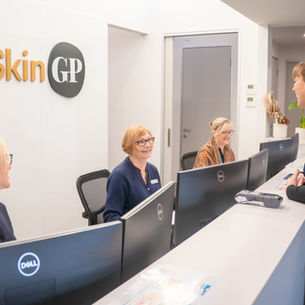 a photo of friendly reception staff smiling and welcoming a new patient at SkinGP Woodend.