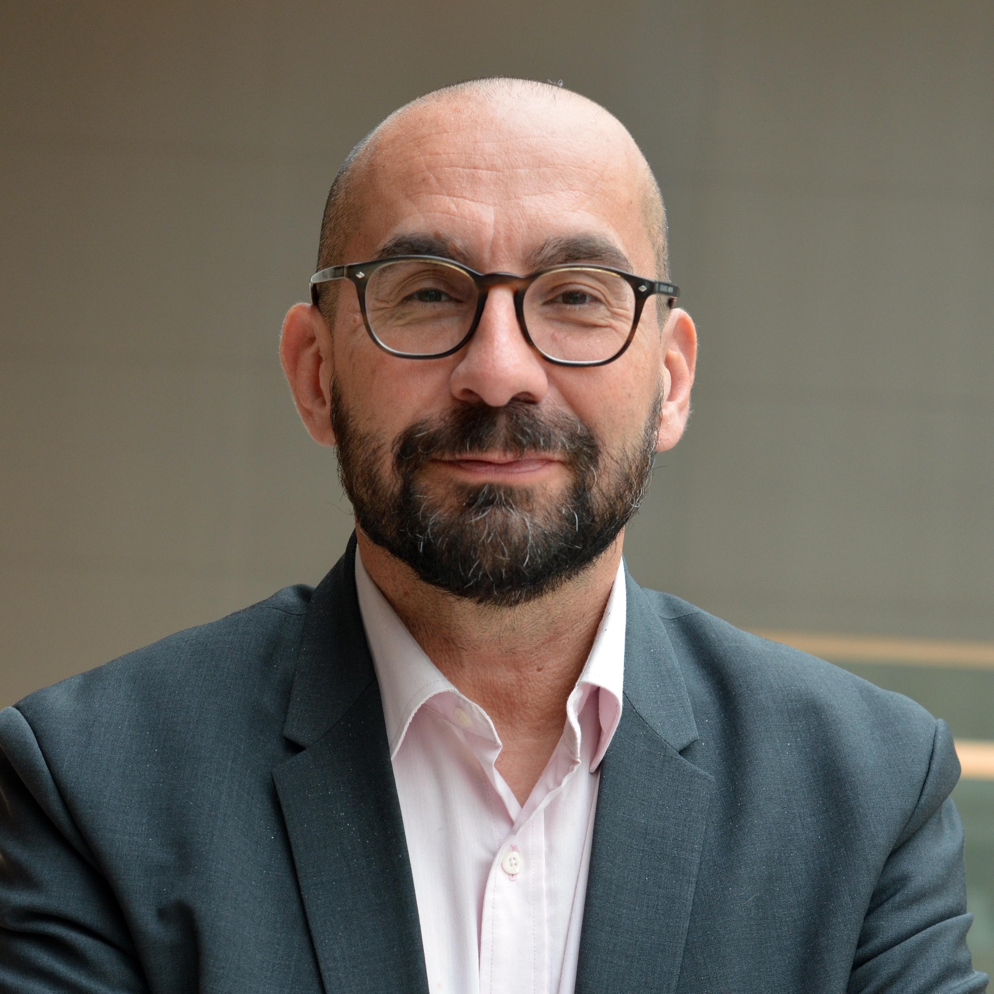 Portrait de Jean-Pierre, homme avec des lunettes et une veste, regardant la caméra.