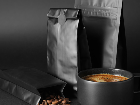 Freshly roasted coffee beans pouring from flexible packaging bag