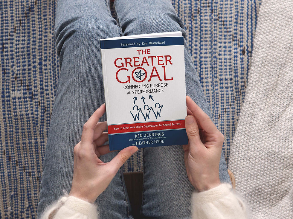 Woman holding the Greater Goal Achievement book, smiling and engaged, symbolizing personal and team growth