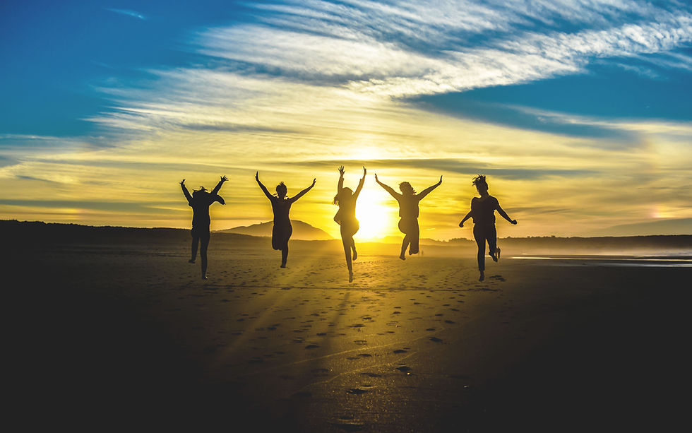 Group of Friends Running Joyfully on Beach at Sunset