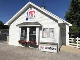 Image of the original TAILS building at Centennial Farm in Grosse Ile. White clapboard building with a peaked roof and two large front windows.