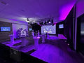 Uplighting and stage lighting setup for a corporate product launch with cocktail tables and projection.