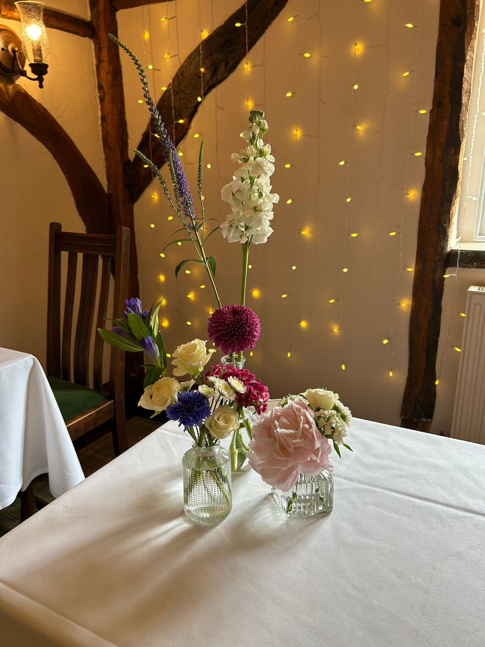 Colourful flowers in bud vases on the registration table.