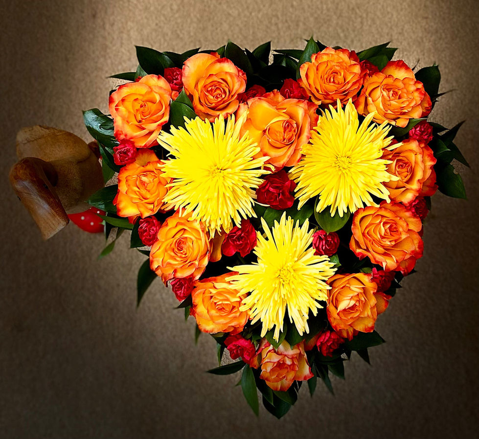 Salisbury Funeral Florist. A bright orange and red rose heart arrangement, with yellow flowers.