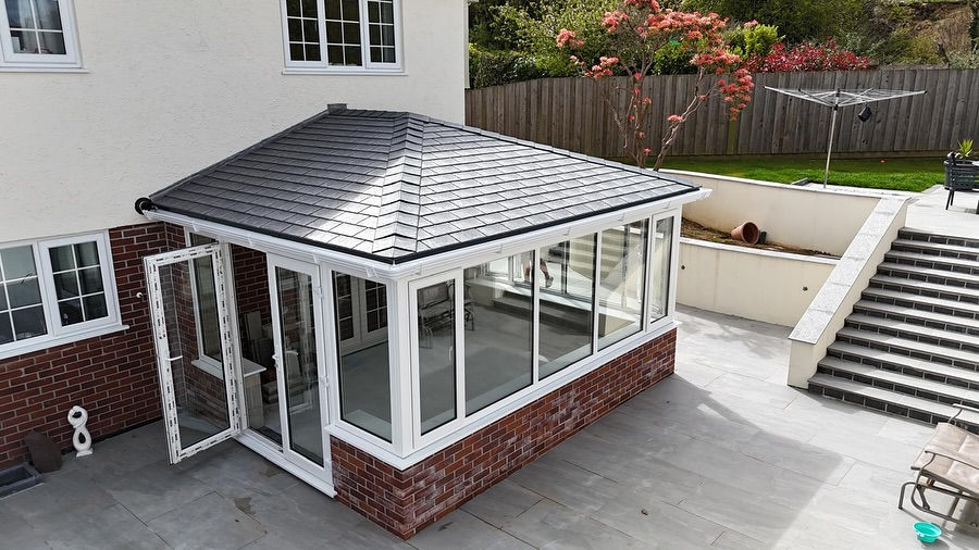 Wide angle view of a custom-built conservatory filled with plants