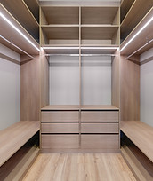 Spacious empty wardrobe with lighting and wooden shelves