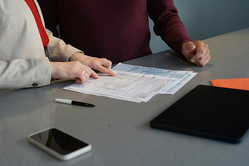 Two people reviewing and filling out paperwork together at a table
