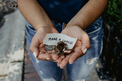 Open hands holding coins and a note that reads Make a Change