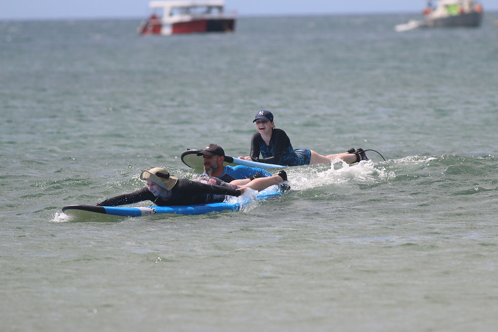 Family surfing together during a private surf lesson in Tamarindo with Salty Smile Surf Camp