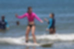 Beginner surfer during a surf lesson in Tamarindo, Costa Rica, enjoying a surf vacation.
