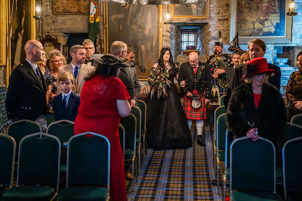 Bride walking down the aisle with her father during her ceremony at Eilean Donan Castle in the Scottish Highland