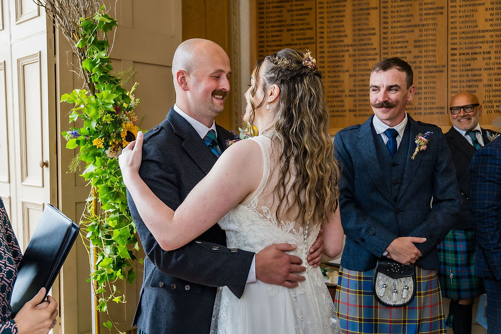 Groom embracing his bride as she reaches him at the end of the aisle during their wedding ceremony.