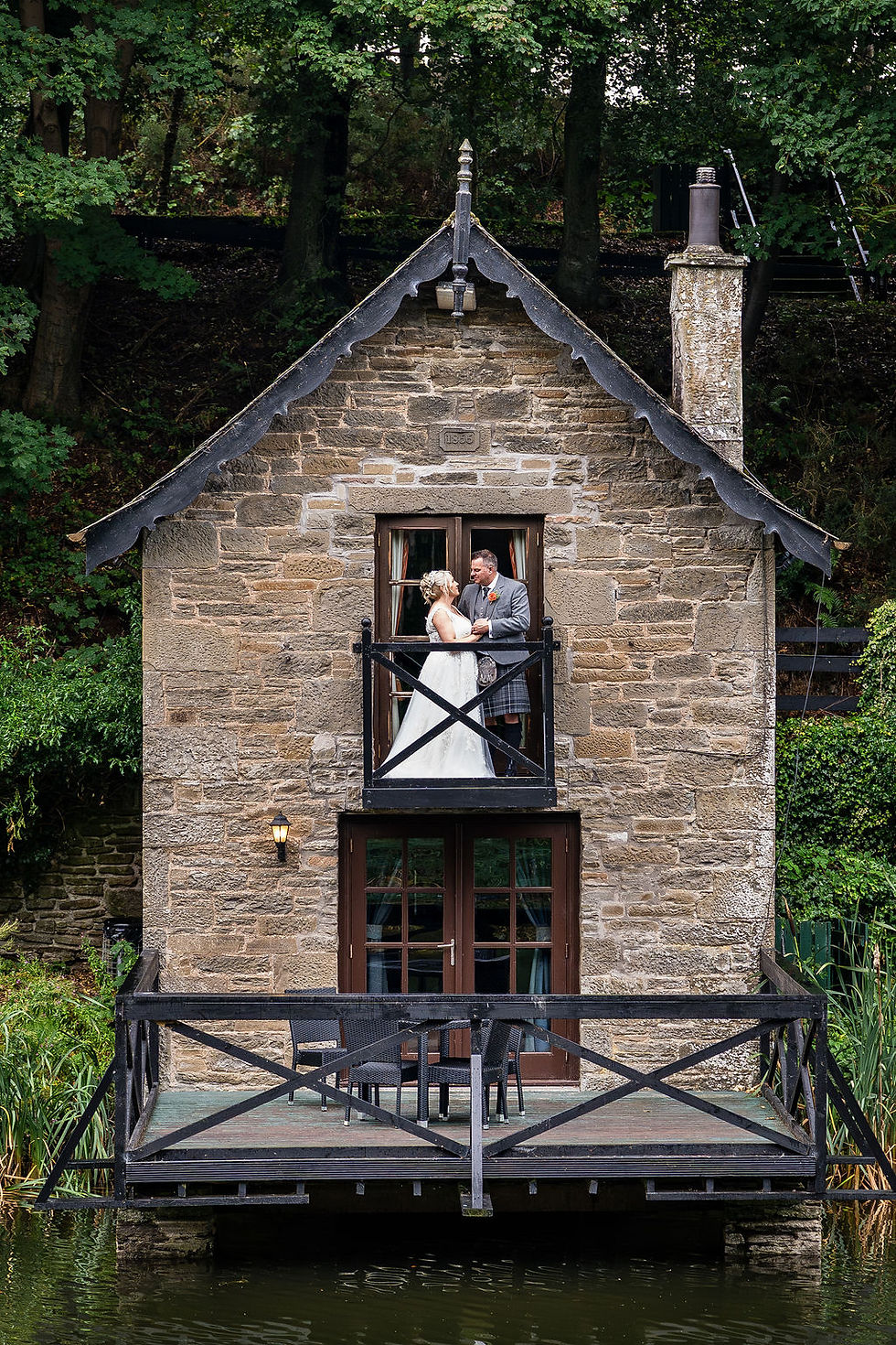 Bride and groom posing for couple portraits on the boathouse at Forbes of Kingennie near Dundee, captured by Dundee wedding photographer ZibiZ Photo.