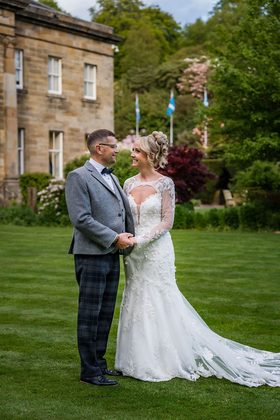 Bride and groom holding hands and looking at each other outside Balbirnie House during wedding portraits