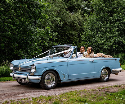 Bride and groom sitting in a classic car outside Kinmount House, captured by a Scottish wedding photographer in a candid and elegant documentary style, perfect for romantic Scotland wedding photography.