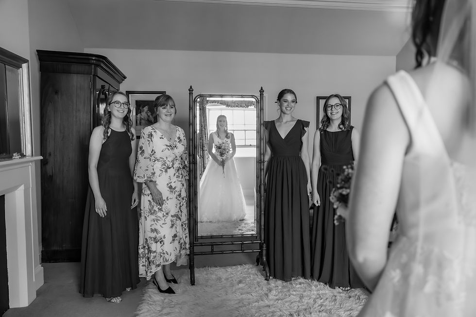 A beautiful, layered reflection showing the bride, her mother, and bridesmaids together in a grand mirror at Scone Palace.