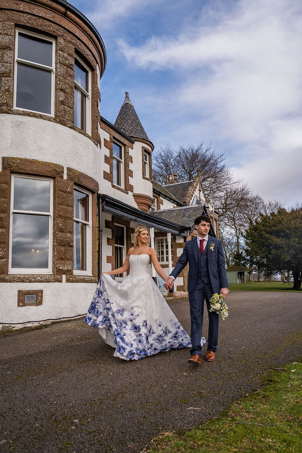 Bride and groom framed by Kinclune House, capturing natural connection in a beautiful Scottish wedding setting