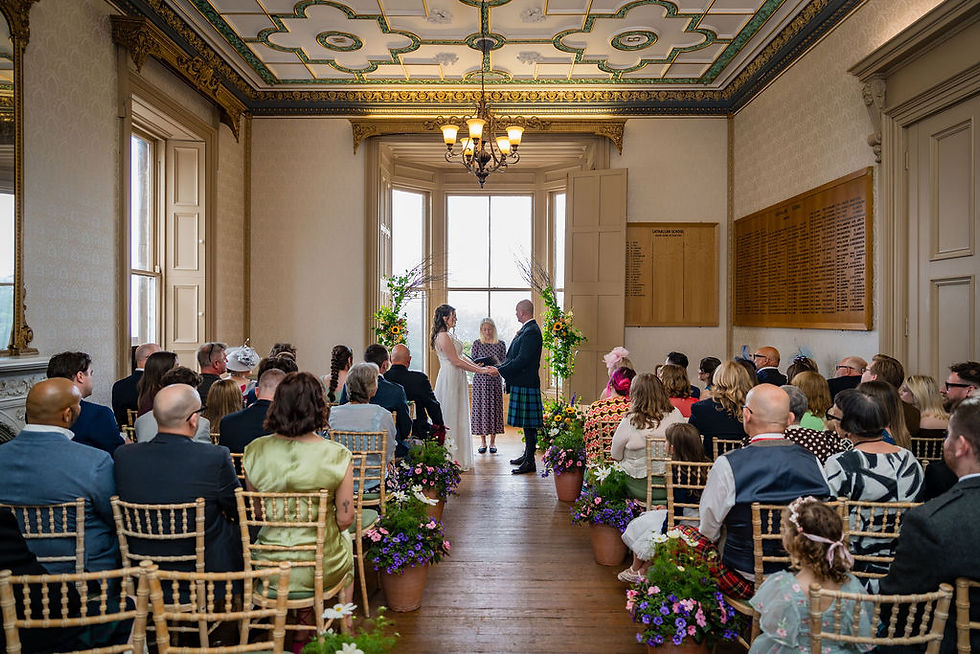 Another wide view of the wedding ceremony at Brotherton Castle showing the couple and their gathered guests.