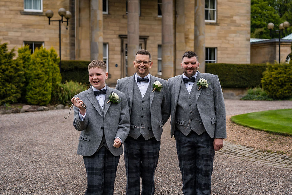 Groom standing with his best man and bride’s son outside Balbirnie House before ceremony, relaxed wedding moment in Scotland