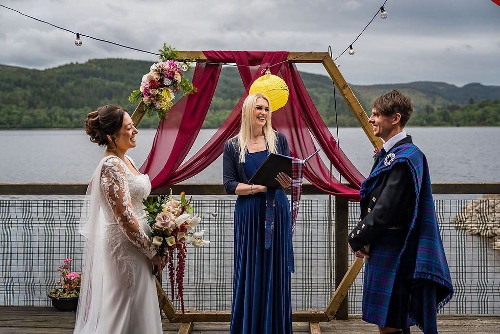 Bride and groom laughing together during outdoor wedding ceremony at Venachar Lochside