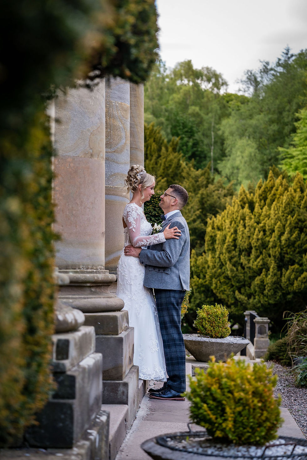 Bride and groom hugging on staircase at Balbirnie House while sharing quiet wedding moment together