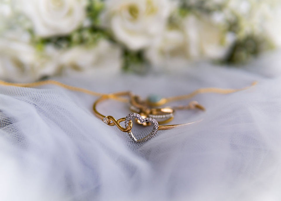 Close-up of bride's jewelry on her veil, with the wedding bouquet in the background, capturing the beautiful details before the wedding at Peebles Hydro.