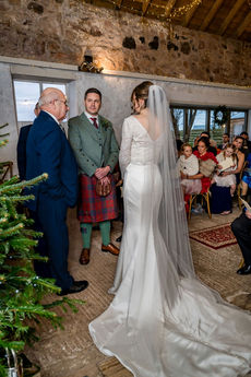 The groom gazes lovingly at his bride during their wedding ceremony.