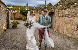 Bride and groom walking hand-in-hand at The Cow Shed Crail, Fife wedding portraits in a rustic setting.