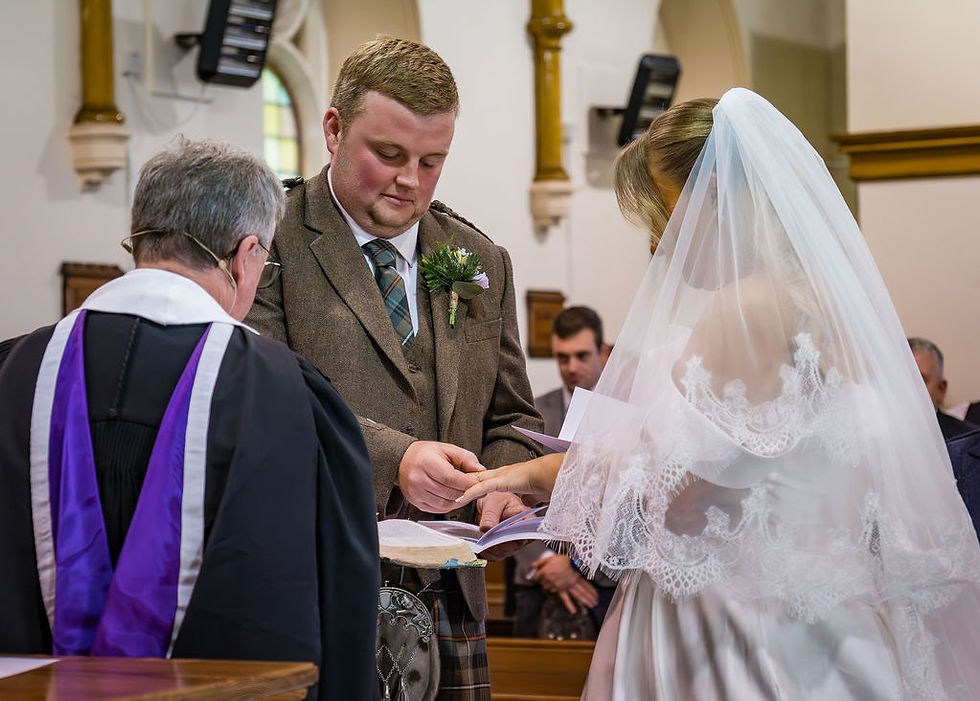 Ring exchange during church wedding ceremony at Barry Parish Church near Carnoustie