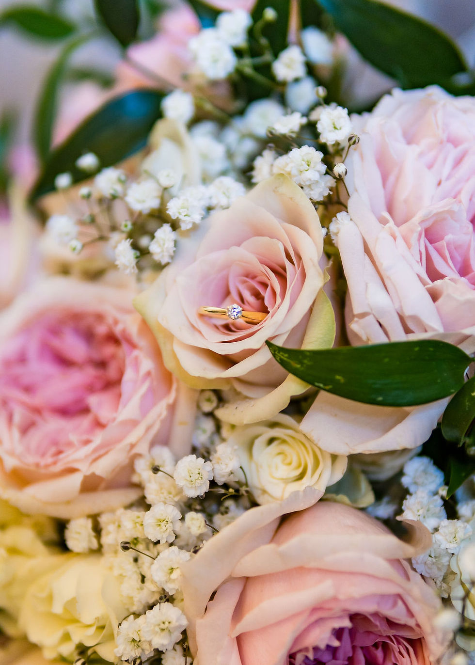 Wedding rings nestled in flowers during bridal preparations, photographed as part of natural wedding details in Scotland