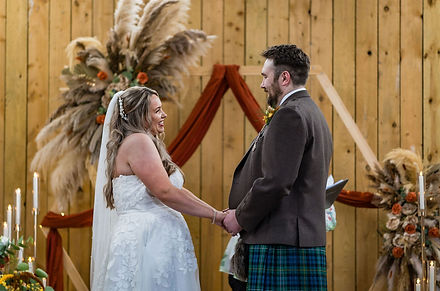 Candid photo of bride and groom laughing together during their autumn wedding portraits in the Scottish countryside, captured by a natural and relaxed Scottish wedding photographer.