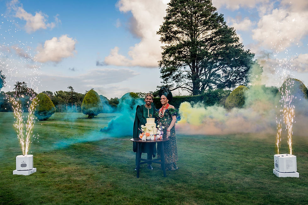 The newlyweds cutting their wedding cake surrounded by sparklers during their first dance at Kinmount House, a joyful Scottish multicultural celebration.