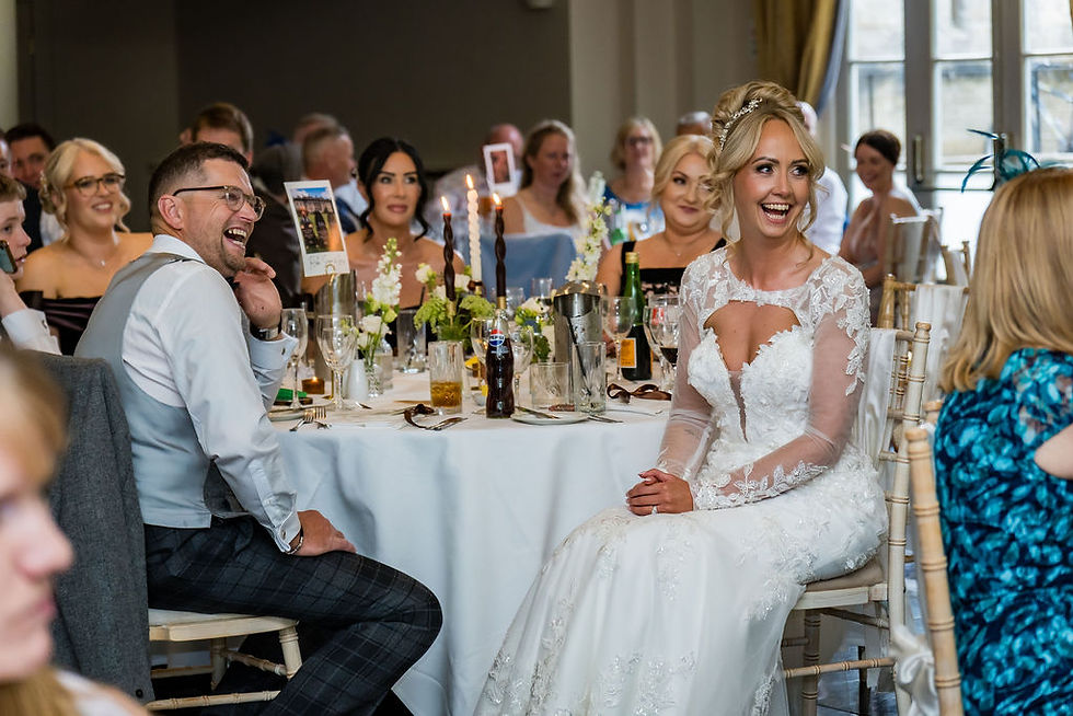 Bride and groom laughing during wedding speeches at Balbirnie House, joyful reception moment in Scotland